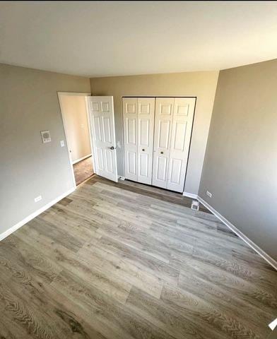 1214 Vista Dr, Gurnee, IL 60031 - unfurnished bedroom with dark wood-type flooring and a closet