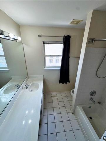 1214 Vista Dr, Gurnee, IL 60031 - full bath featuring healthy amount of natural light, vanity, shower / tub combination, and tile patterned floors