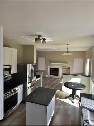 1214 Vista Dr, Gurnee, IL 60031 - kitchen featuring stainless steel appliances, dark countertops, white cabinetry, and dark wood-style floors