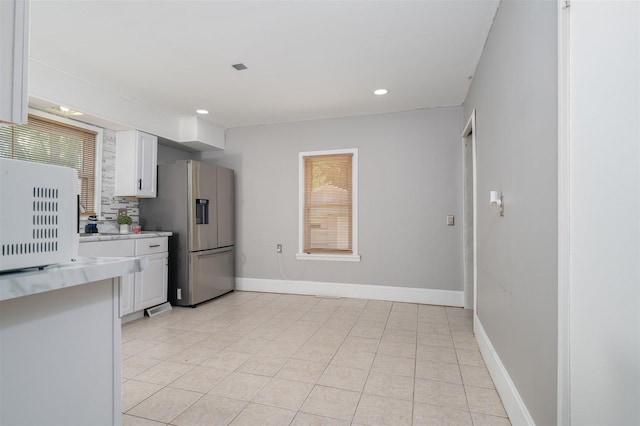 1006 S Adelaide St, Normal, IL 61761 - kitchen with stainless steel fridge, light countertops, white cabinets, recessed lighting, and light tile patterned floors