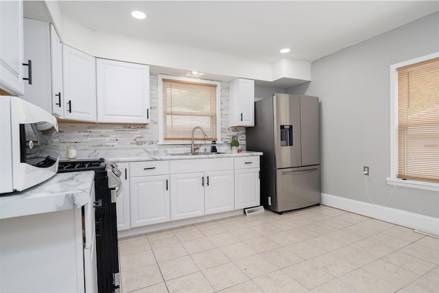 1006 S Adelaide St, Normal, IL 61761 - kitchen with stainless steel appliances, tasteful backsplash, white cabinetry, light tile patterned floors, and recessed lighting