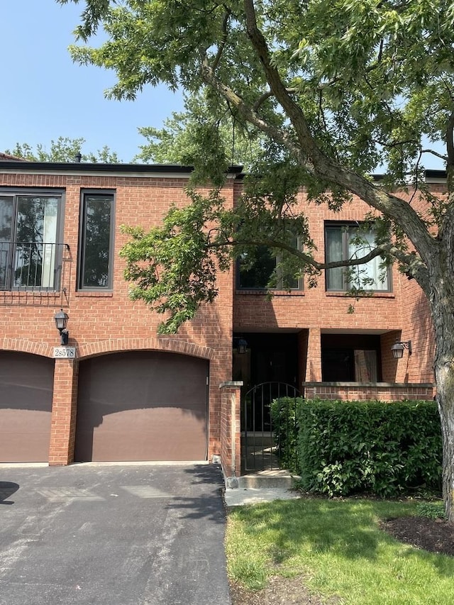 2S578 Patrick Henry Sq Unit 578, Oak Brook, IL 60523 - view of front of house with brick siding, a garage, and asphalt driveway