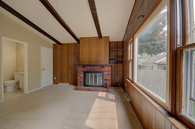 1318 N Prairie Ave, Joliet, IL 60435 - unfurnished living room featuring wood walls, healthy amount of natural light, a fireplace, light colored carpet, and a baseboard heating unit