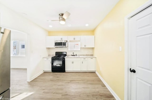 1216 Park Ave, Chicago Heights, IL 60411 - kitchen with appliances with stainless steel finishes, white cabinetry, ceiling fan, and light wood finished floors