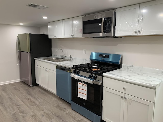 2155 N Mobile Ave, Chicago, IL 60639 - kitchen featuring stainless steel appliances, light wood-type flooring, white cabinetry, and recessed lighting