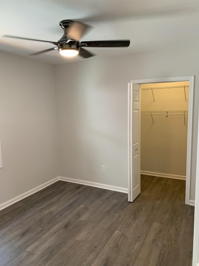 2155 N Mobile Ave, Chicago, IL 60639 - unfurnished bedroom with dark wood-style flooring, a walk in closet, a closet, and a ceiling fan