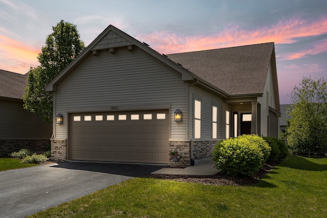 565 Sudbury Cir Unit 0, Oswego, IL 60543 - view of front of home with driveway, an attached garage, a lawn, a shingled roof, and stone siding