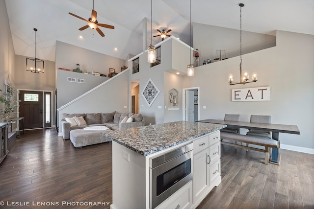 565 Sudbury Cir Unit 0, Oswego, IL 60543 - kitchen with stainless steel microwave, ceiling fan, high vaulted ceiling, a chandelier, and dark wood-type flooring