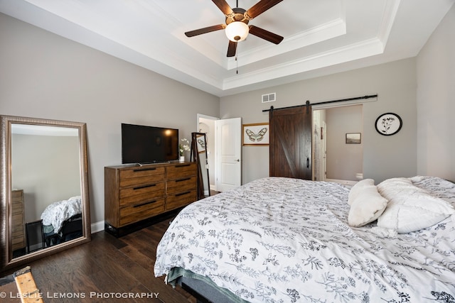 565 Sudbury Cir Unit 0, Oswego, IL 60543 - bedroom with dark wood finished floors, a barn door, a tray ceiling, ornamental molding, and a ceiling fan