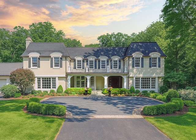 611 Oak Knoll Dr, Lake Forest, IL 60045 - french provincial home featuring a balcony, curved driveway, a chimney, stucco siding, and a porch