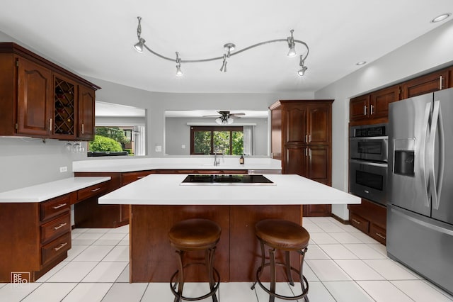 641 E Belmont Ave, Addison, IL 60101 - kitchen with stainless steel appliances, a breakfast bar, light countertops, a kitchen island, and light tile patterned floors