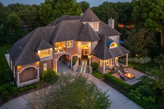 1091 Johnson Dr, Naperville, IL 60540 - french provincial home with a fire pit, driveway, french doors, a chimney, and stairs