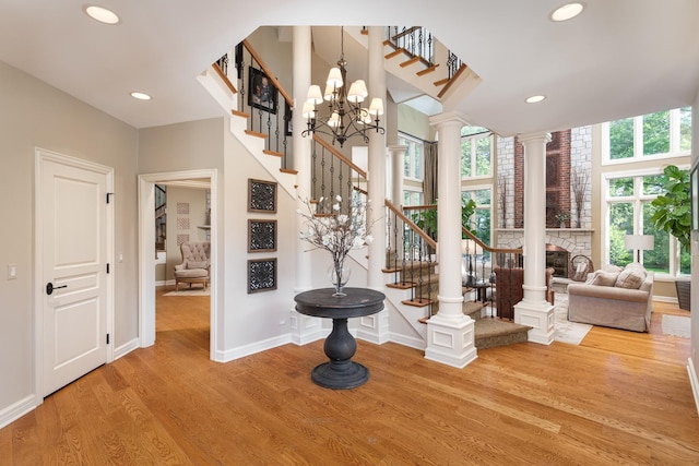 1091 Johnson Dr, Naperville, IL 60540 - foyer entrance featuring stairs, wood finished floors, recessed lighting, ornate columns, and a fireplace