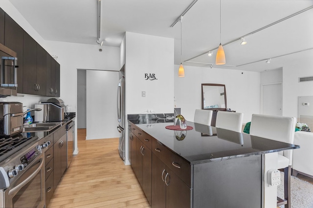 8 E Randolph St Unit 1401, Chicago, IL 60601 - kitchen featuring rail lighting, appliances with stainless steel finishes, light wood-type flooring, a kitchen bar, and a peninsula