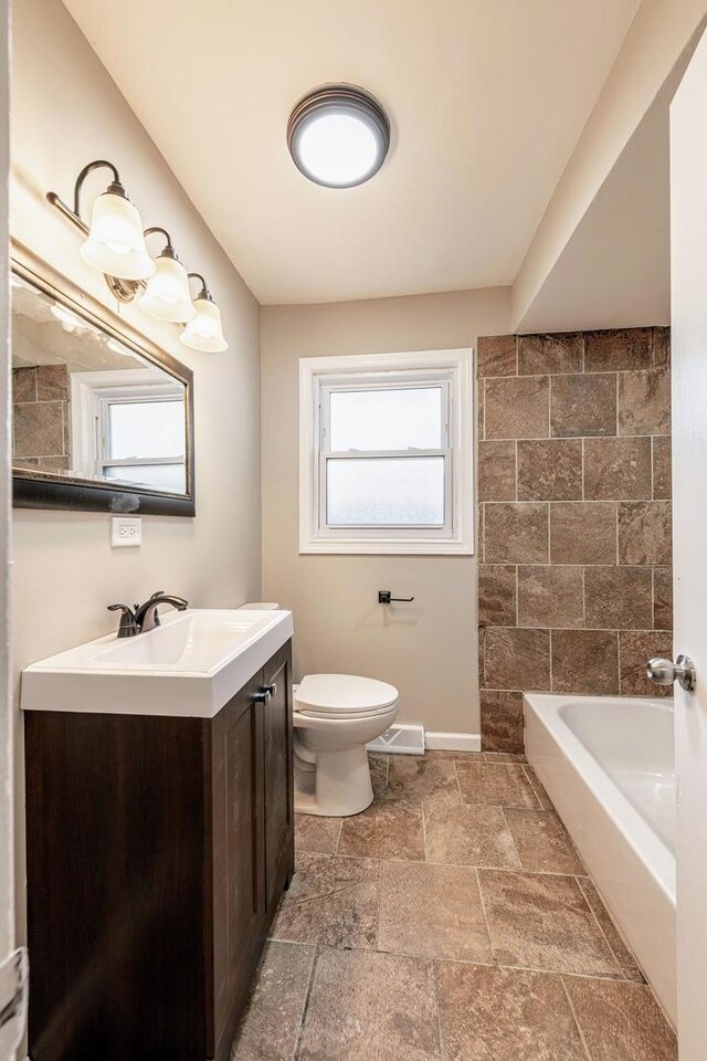 14415 Avalon Ave, Dolton, IL 60419 - full bath with vanity, a bathtub, and stone tile floors