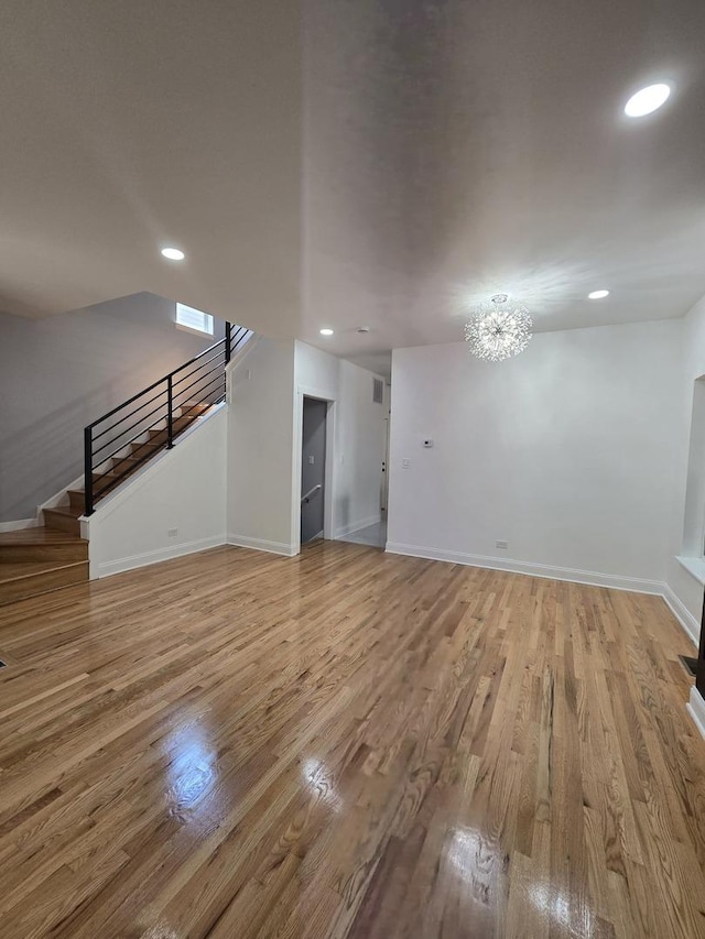 8620 S Normal Ave, Chicago, IL 60620 - unfurnished living room with stairs, light wood-type flooring, recessed lighting, and a chandelier