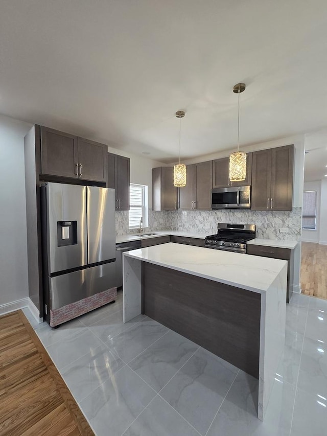 8620 S Normal Ave, Chicago, IL 60620 - kitchen with appliances with stainless steel finishes, decorative backsplash, light countertops, dark brown cabinetry, and pendant lighting