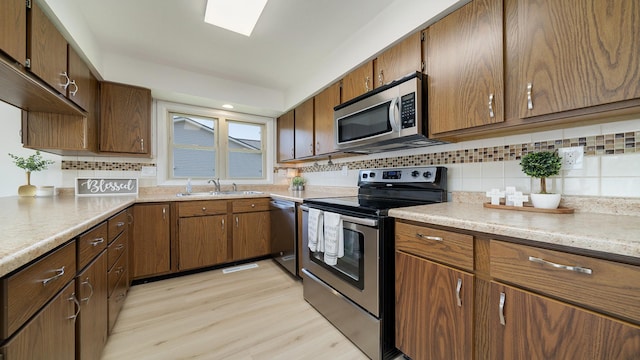 1320 Lake Summerset Rd, Davis, IL 61019 - kitchen featuring appliances with stainless steel finishes, decorative backsplash, light countertops, light wood-type flooring, and brown cabinets