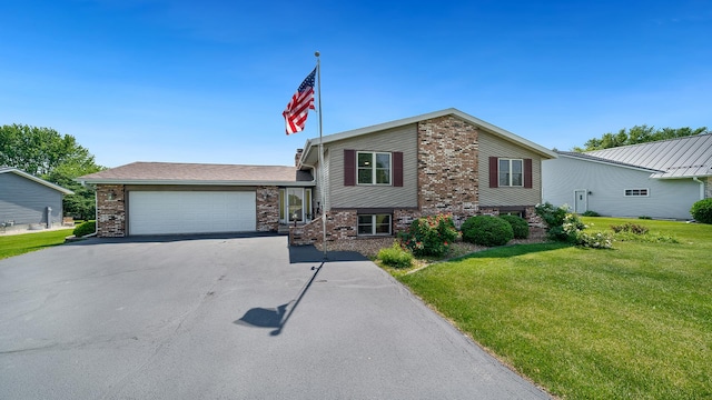 1320 Lake Summerset Rd, Davis, IL 61019 - split level home featuring asphalt driveway, a garage, a front lawn, and brick siding