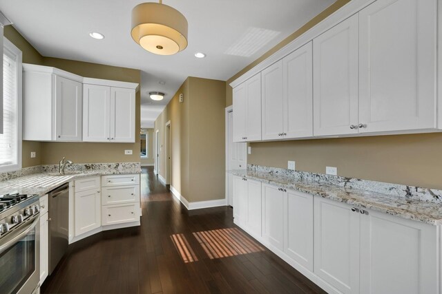 2732 W Belmont Ave, Chicago, IL 60618 - kitchen with appliances with stainless steel finishes, dark wood-style flooring, white cabinets, recessed lighting, and light stone counters