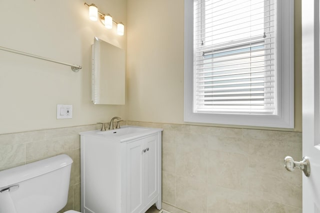 2732 W Belmont Ave, Chicago, IL 60618 - bathroom with tile walls, plenty of natural light, vanity, and wainscoting