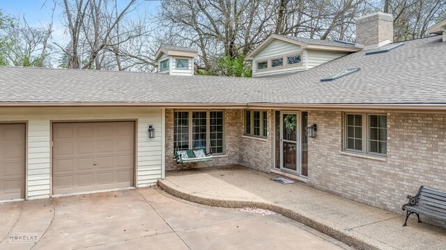 7S745 State Route 53rd Hwy, Naperville, IL 60540 - view of front facade featuring roof with shingles, concrete driveway, brick siding, a chimney, and a garage