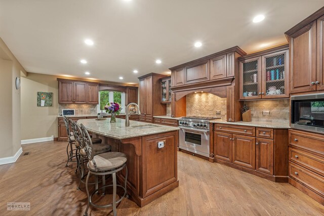 7S745 State Route 53rd Hwy, Naperville, IL 60540 - kitchen featuring stainless steel range, light stone counters, tasteful backsplash, a breakfast bar area, and black microwave