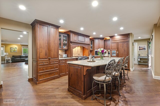 7S745 State Route 53rd Hwy, Naperville, IL 60540 - kitchen featuring dark wood-style floors, glass insert cabinets, recessed lighting, a kitchen island with sink, and a breakfast bar area