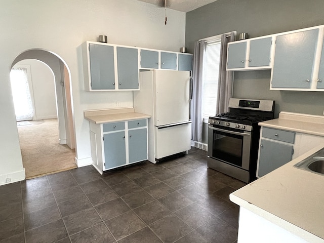 42 2nd St, Lasalle, IL 61301 - kitchen with stainless steel gas range oven, freestanding refrigerator, arched walkways, light countertops, and a ceiling fan