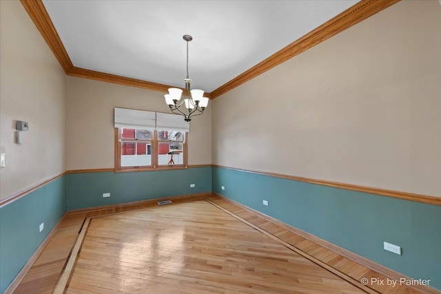 514 Doral Ln, North Aurora, IL 60542 - spare room featuring crown molding, wood finished floors, and a chandelier