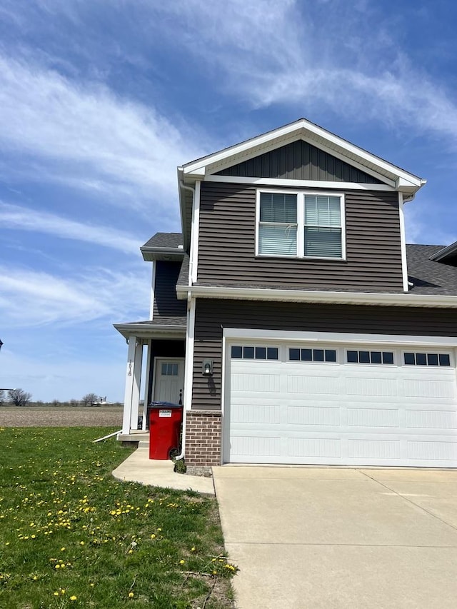 1516 Stonebluff Ct, Champaign, IL 61822 - view of front of property with a front yard, concrete driveway, a garage, brick siding, and board and batten siding