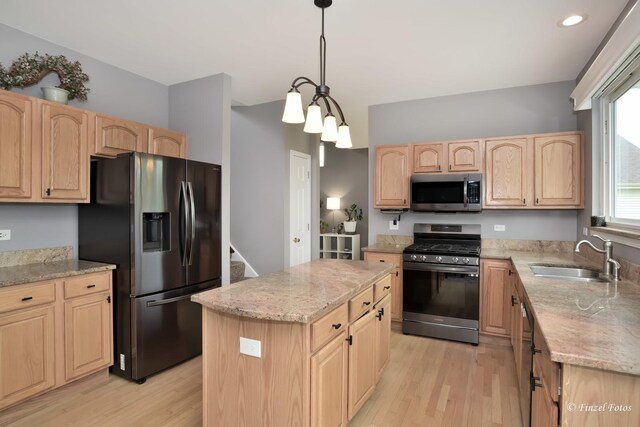 2012 Spring Creek Ln, Mchenry, IL 60050 - kitchen featuring appliances with stainless steel finishes, light brown cabinets, light wood-style floors, light stone countertops, and a kitchen island
