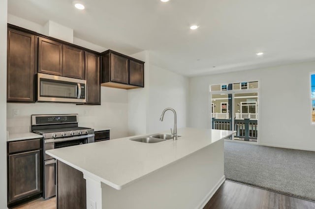 2167 Yellowstone Blvd, Mundelein, IL 60060 - kitchen featuring appliances with stainless steel finishes, dark brown cabinetry, an island with sink, light countertops, and recessed lighting