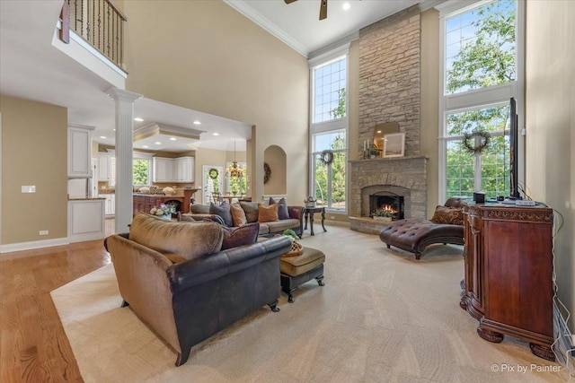 675 Oak Ln, South Elgin, IL 60177 - living room with a towering ceiling, ornamental molding, a stone fireplace, decorative columns, and wood finished floors