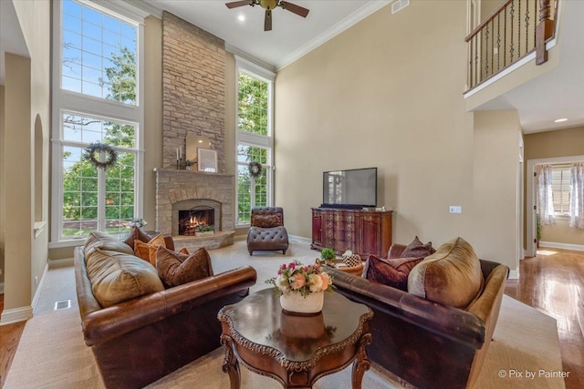 675 Oak Ln, South Elgin, IL 60177 - living room featuring a high ceiling, wood finished floors, ceiling fan, crown molding, and a stone fireplace