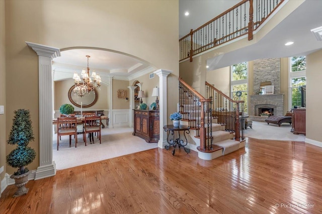 675 Oak Ln, South Elgin, IL 60177 - foyer featuring decorative columns, wood finished floors, a fireplace, and a towering ceiling