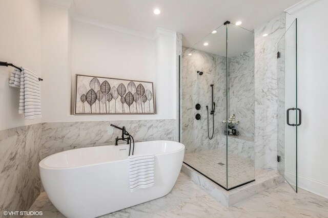 full bath with a marble finish shower, marble finish floors, crown molding, a freestanding bath, and tile walls