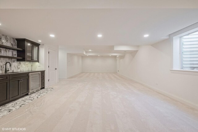 indoor wet bar featuring beverage cooler, tasteful backsplash, recessed lighting, and light carpet