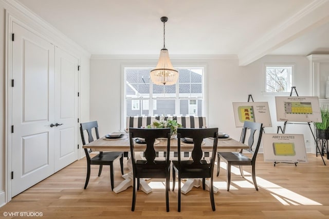 dining room featuring a chandelier, light wood-type flooring, and crown molding