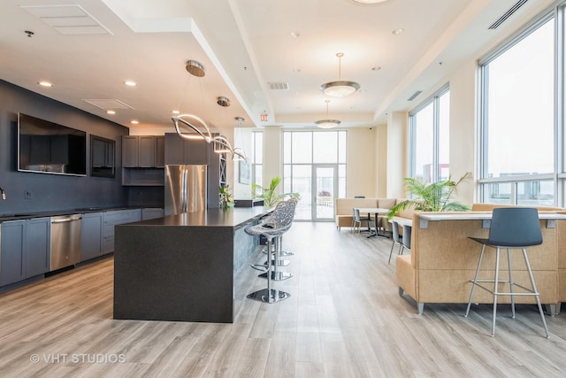 1841 S Calumet Ave Unit 1304, Chicago, IL 60616 - kitchen with stainless steel appliances, a breakfast bar, light wood-type flooring, dark countertops, and a center island
