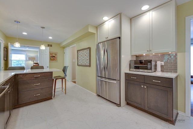 2120 Wilmette Ave, Wilmette, IL 60091 - kitchen featuring freestanding refrigerator, light countertops, white cabinetry, light marble finish flooring, and backsplash