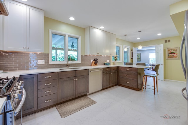 2120 Wilmette Ave, Wilmette, IL 60091 - kitchen featuring stainless steel appliances, a peninsula, light countertops, white cabinetry, and decorative backsplash