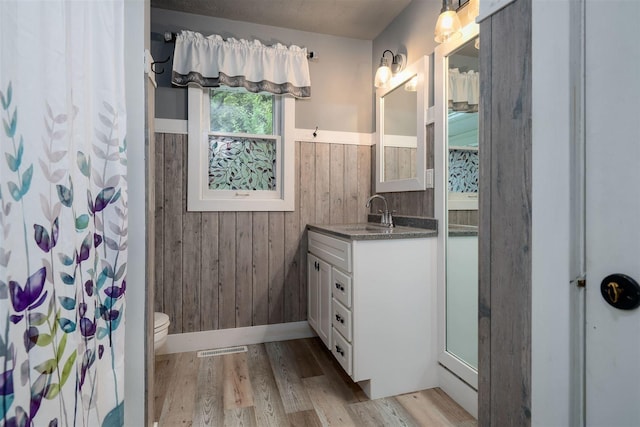 212 Rebecca Ln, Normal, IL 61761 - bathroom with vanity, wood finished floors, wooden walls, a wainscoted wall, and a shower with shower curtain