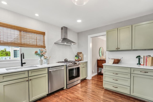 17526 W Windhaven Ct, Grayslake, IL 60030 - kitchen with island exhaust hood, stainless steel appliances, green cabinets, light countertops, and light wood-style flooring