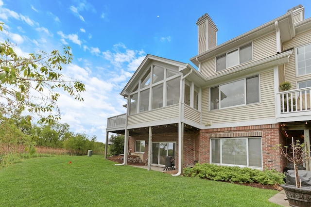 17526 W Windhaven Ct, Grayslake, IL 60030 - rear view of property featuring brick siding, a sunroom, a yard, and a chimney