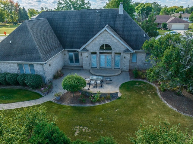 305 Orchard Ln, Beecher, IL 60401 - back of house featuring brick siding, a chimney, a lawn, a patio area, and roof with shingles