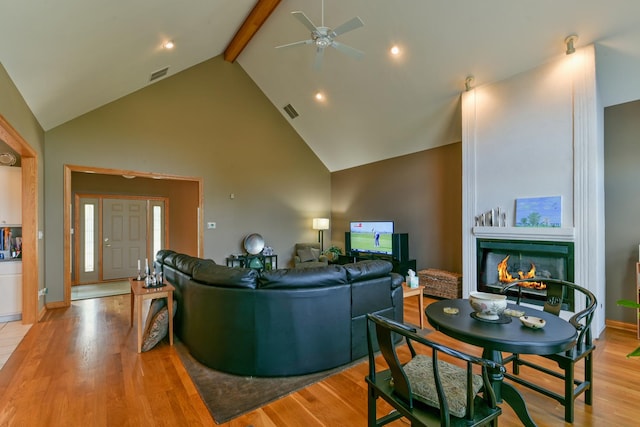 305 Orchard Ln, Beecher, IL 60401 - living area with light wood-style flooring, a ceiling fan, beam ceiling, a lit fireplace, and high vaulted ceiling