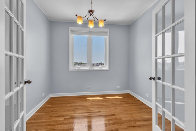 7153 W Irving Park Rd Unit 3, Chicago, IL 60634 - unfurnished room featuring french doors, a chandelier, and wood finished floors