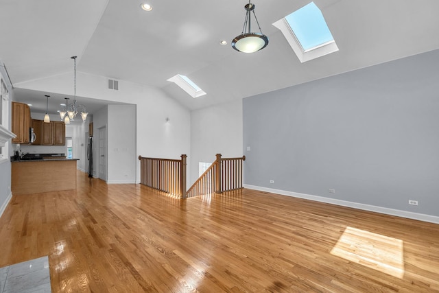 7153 W Irving Park Rd Unit 3, Chicago, IL 60634 - unfurnished living room featuring a skylight, lofted ceiling, light wood-type flooring, and a chandelier
