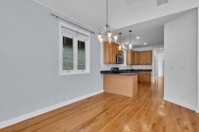 7153 W Irving Park Rd Unit 3, Chicago, IL 60634 - kitchen featuring appliances with stainless steel finishes, dark countertops, a peninsula, light wood finished floors, and pendant lighting